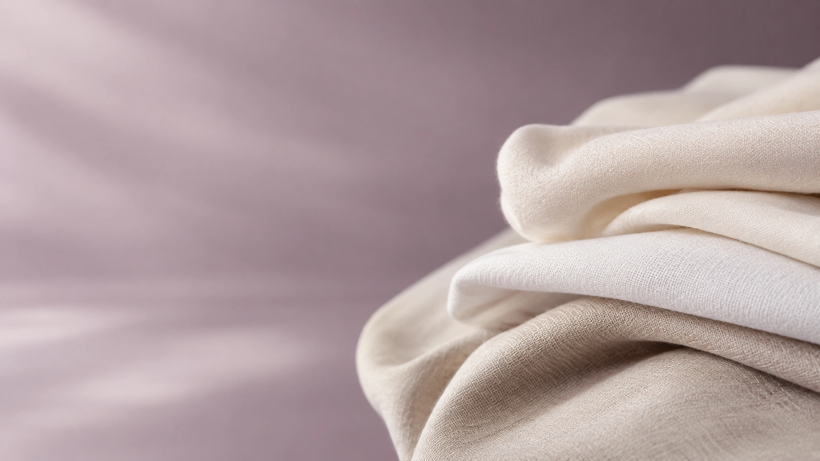 Premium white and cream folded textile fabric with soft mauve background